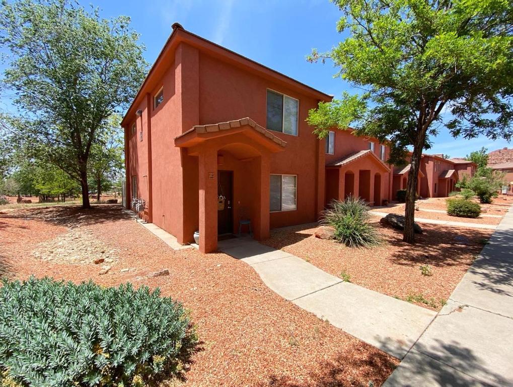 ein rotes Backsteinhaus mit Bäumen und einer Auffahrt in der Unterkunft Pool & Hot Tub Close to hiking trails in Kanab in Kanab