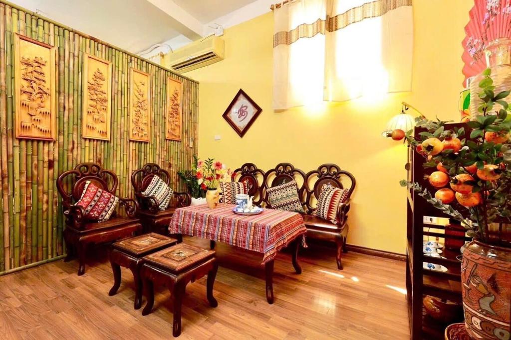 a living room with chairs and a table and a table and chairs at Charm Home 2 in Hanoi