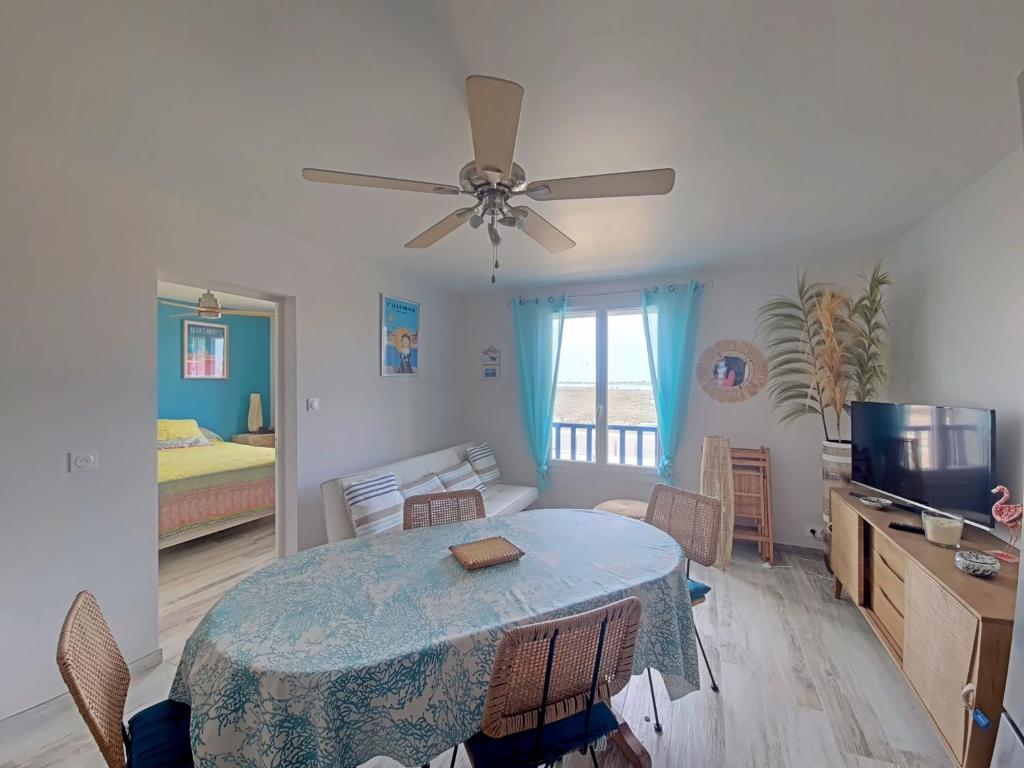 un salon avec une table et une chambre dans l'établissement Appartement 4 pers, pieds dans l'eau avec parking - FR-1-475-217, à Saintes-Maries-de-la-Mer
