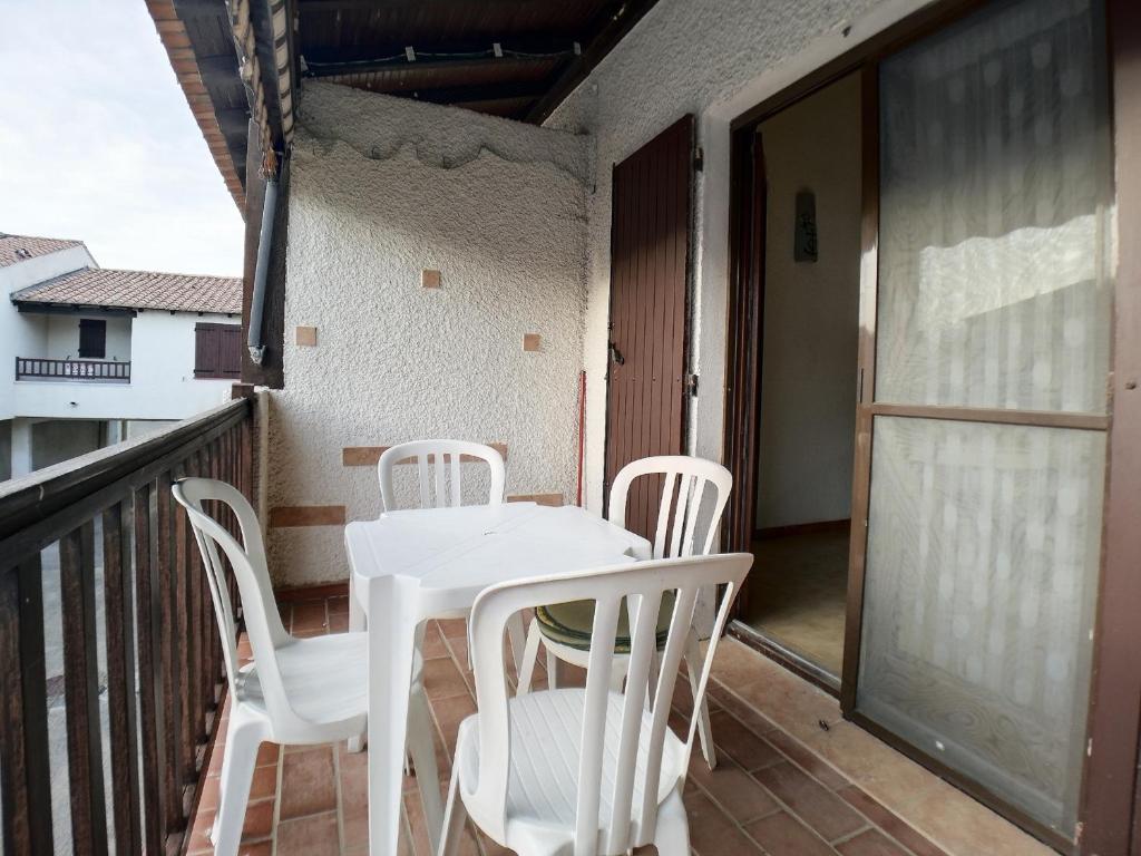 une table blanche et des chaises sur un balcon dans l'établissement Appartement climatisé 4 pers avec parking aux Saintes-Maries-de-la-Mer - FR-1-475-216, à Saintes-Maries-de-la-Mer
