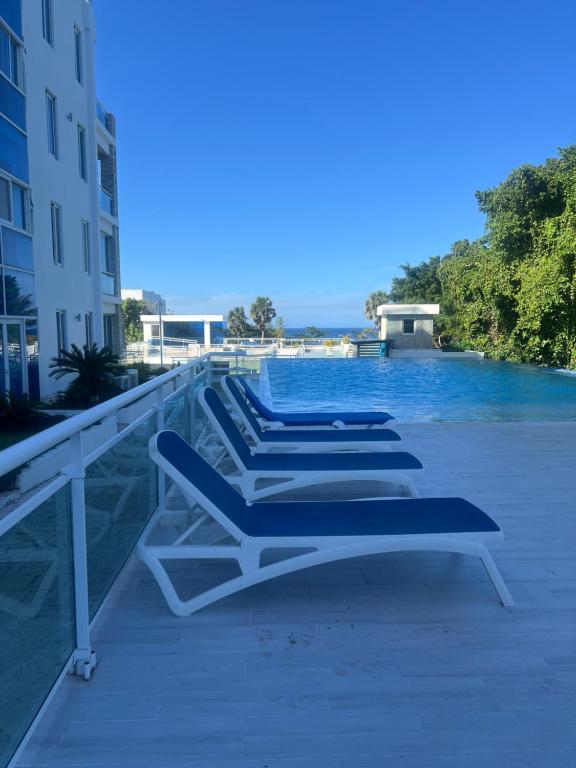 a row of lounge chairs sitting on the side of a pool at Laguna beach in Sosúa