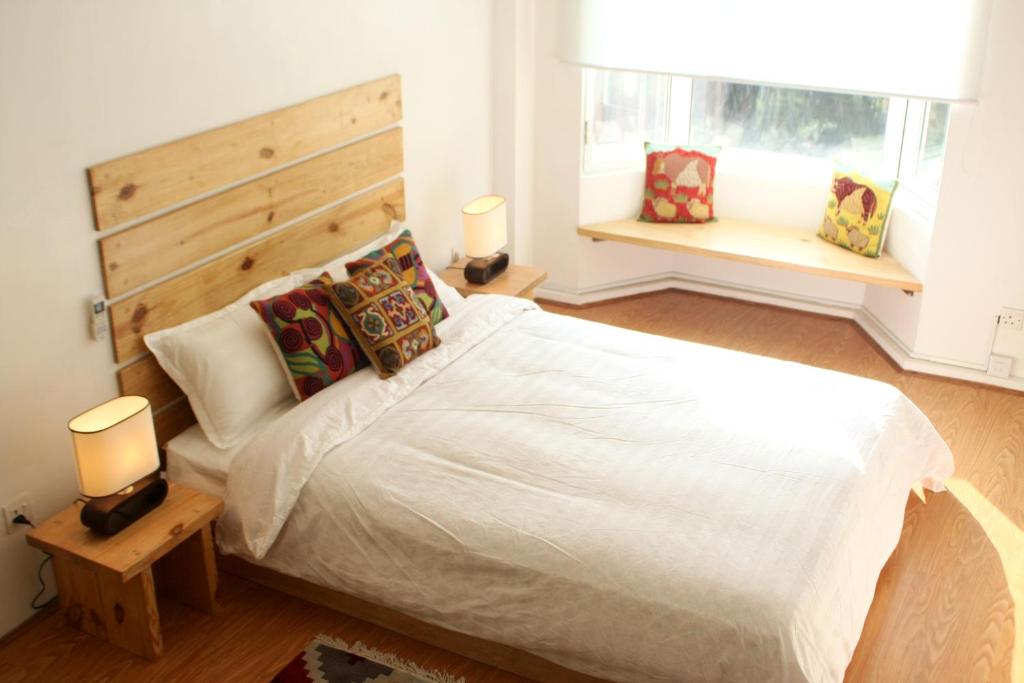 a bedroom with a large white bed and two windows at Ananya Apartments Phase 1 in Kathmandu