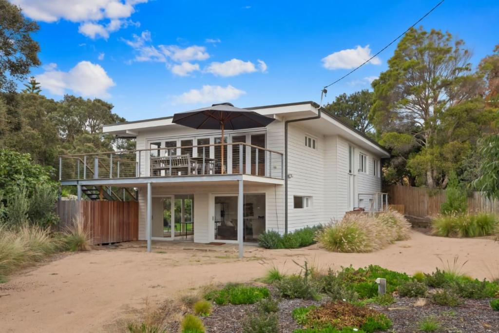 a house with an umbrella on top of it at Coastal White House in Point Lonsdale