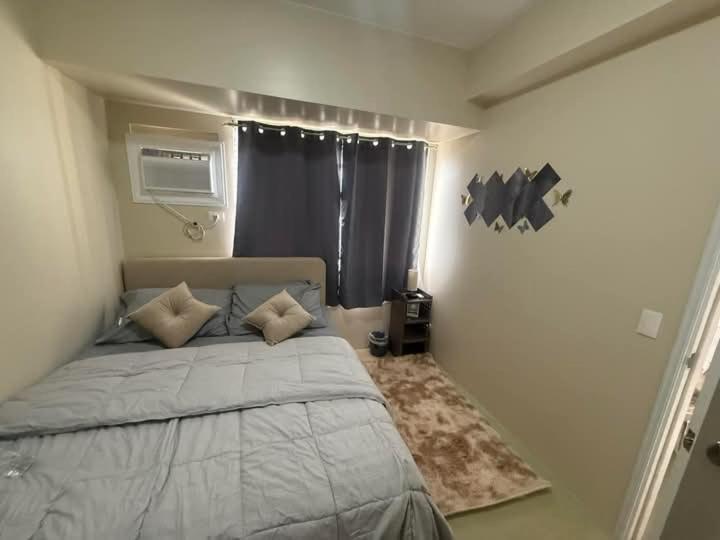 a bedroom with a large bed with a window at Amoore Avida Tower 2 in Cagayan de Oro