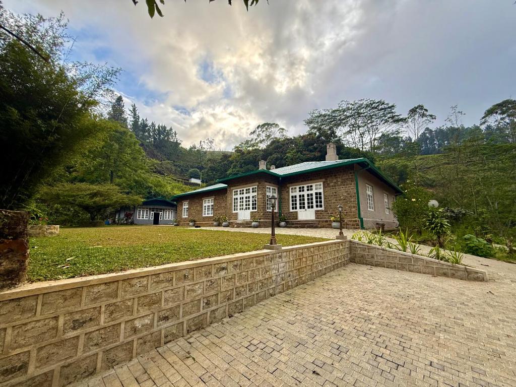 a house with a brick fence in front of it at Watawala Tea Plantation Bungalow in Rozella
