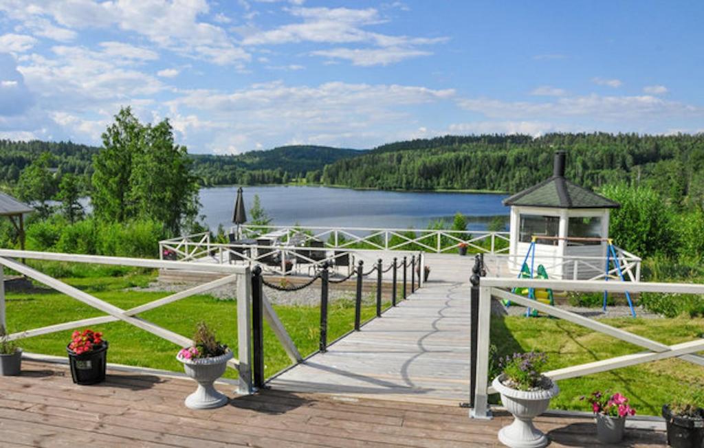 a boardwalk with a gazebo and a lake at Lovely home in Ringstad in Kil