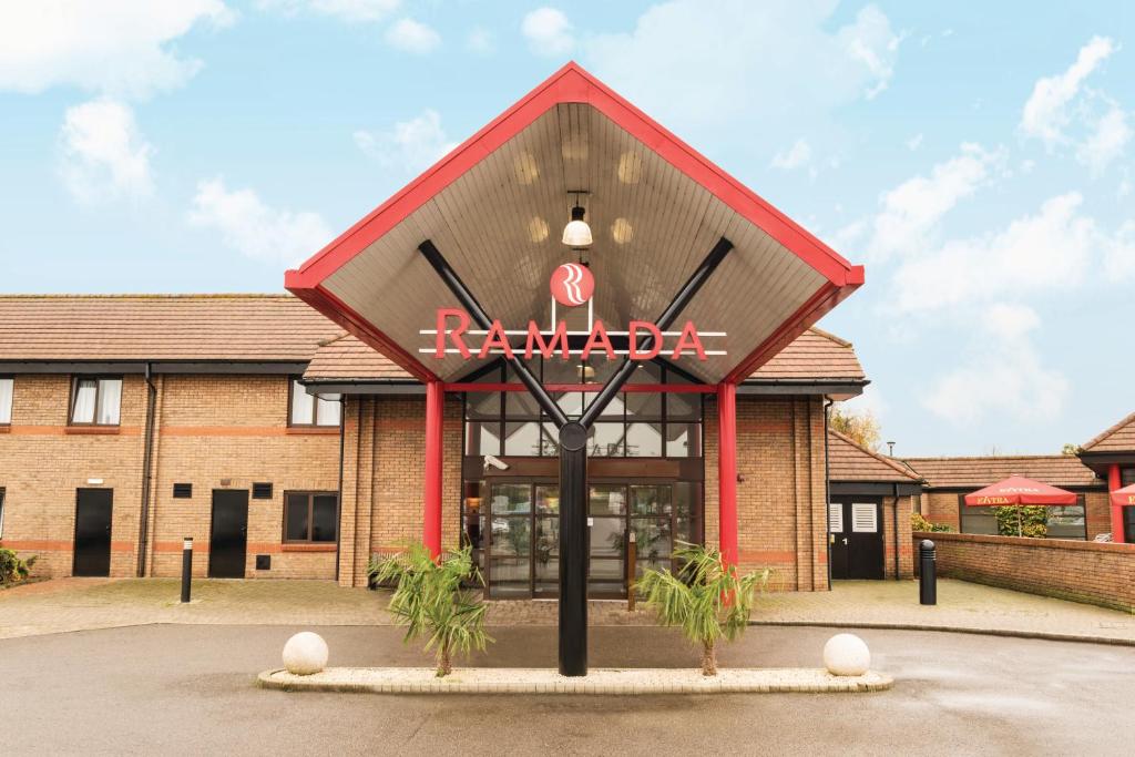 a building with a sign on the front of it at Ramada Cambridge in Cambridge