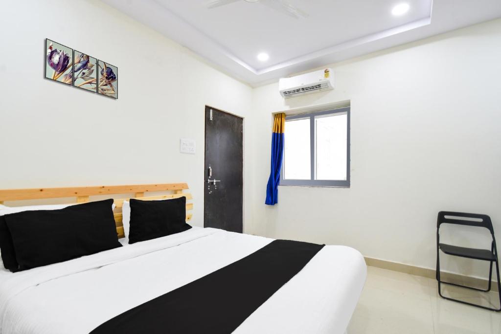 a bedroom with a black and white bed and a window at Super Collection O Adibatla Hyderabad in Ibrāhīmpatan