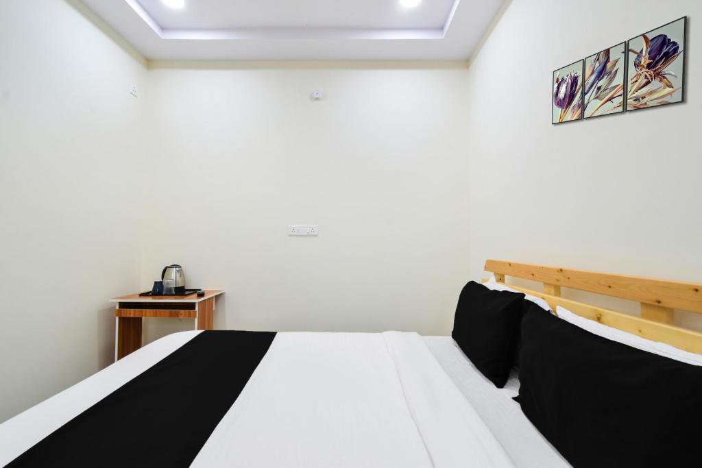 a bedroom with a bed with black and white sheets at Super Collection O Adibatla Hyderabad in Ibrāhīmpatan