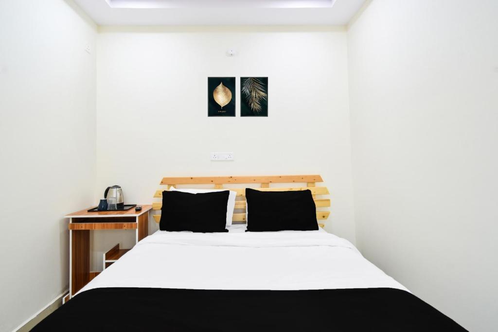 a bedroom with a white bed and a wooden desk at Super Collection O Adibatla Hyderabad in Ibrāhīmpatan