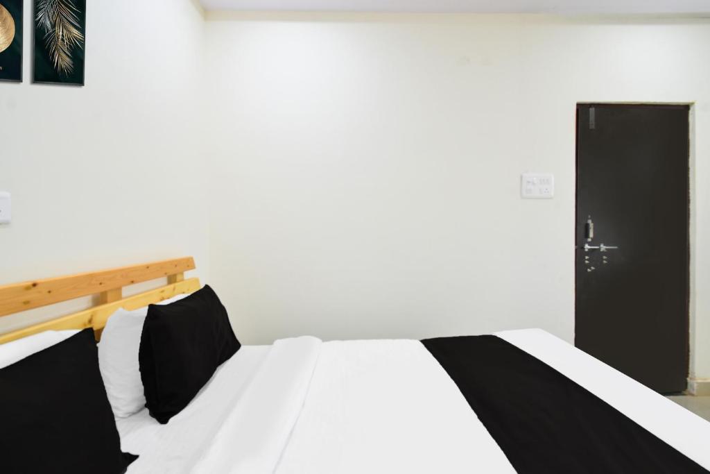 a bedroom with a bed with black and white sheets at Super Collection O Adibatla Hyderabad in Ibrāhīmpatan
