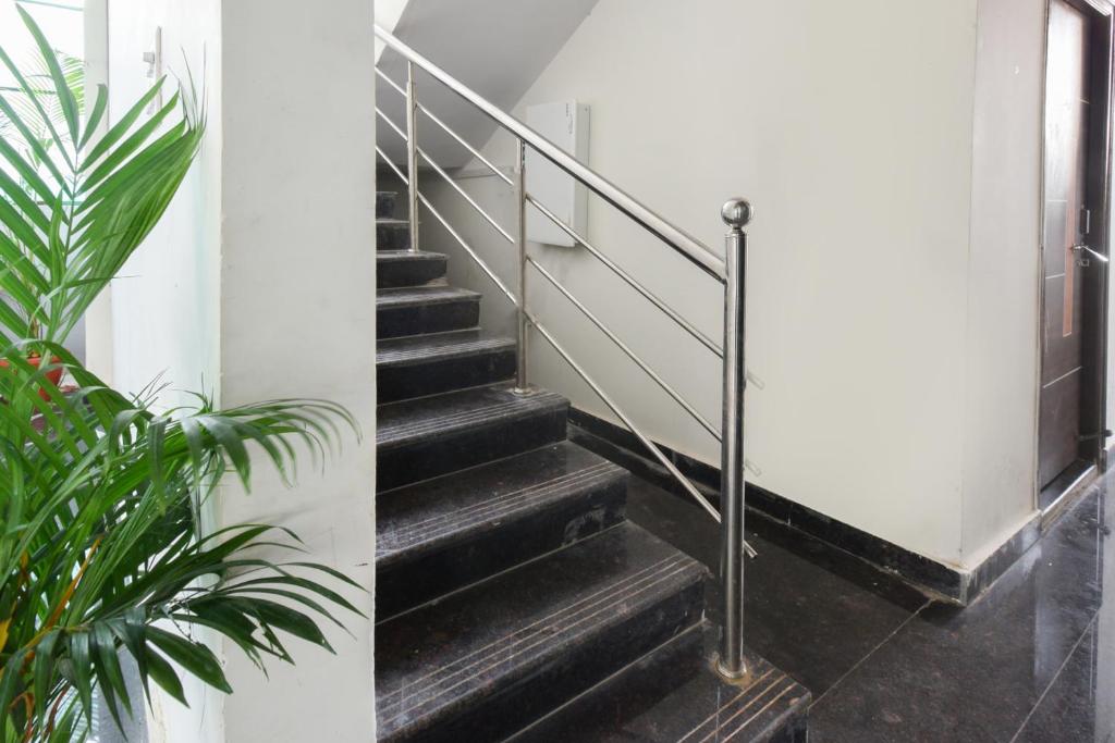 a staircase with a metal hand rail and a plant at Super Collection O Adibatla Hyderabad in Ibrāhīmpatan