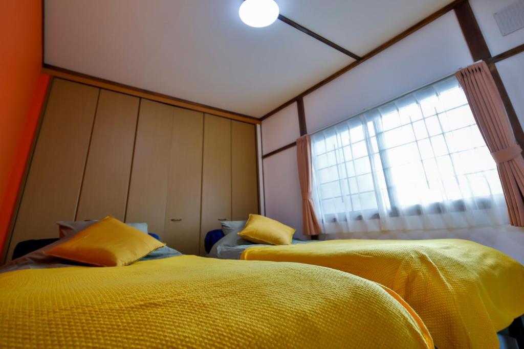 網走市にあるMove8の黄色いシーツと窓が備わる2人部屋です。