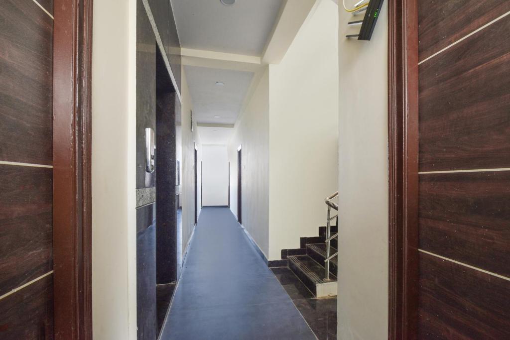 a hallway with a long floor and a wooden door at Super Collection O Adibatla Hyderabad in Ibrāhīmpatan