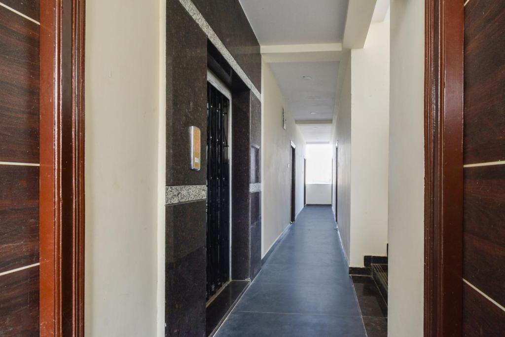 a hallway with white walls and a long hallway at Super Collection O Adibatla Hyderabad in Ibrāhīmpatan