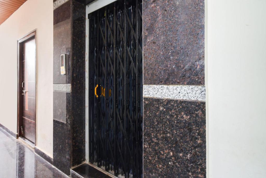 a black door with the letter c on the side of a building at Super Collection O Adibatla Hyderabad in Ibrāhīmpatan