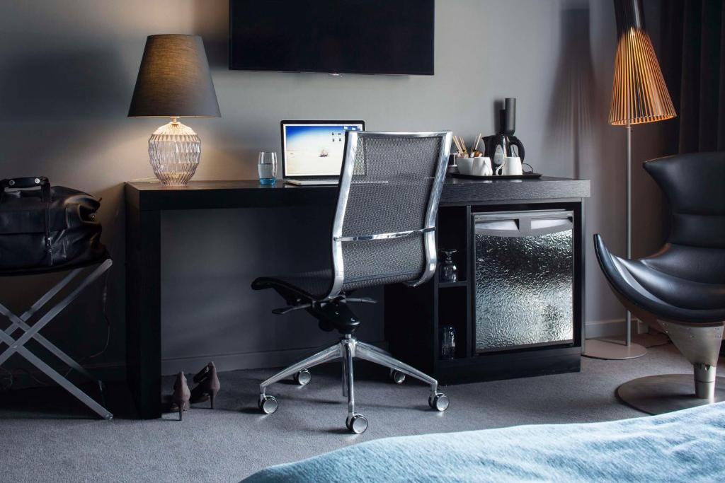 a desk with a computer monitor and a chair at Scandic Front in Copenhagen