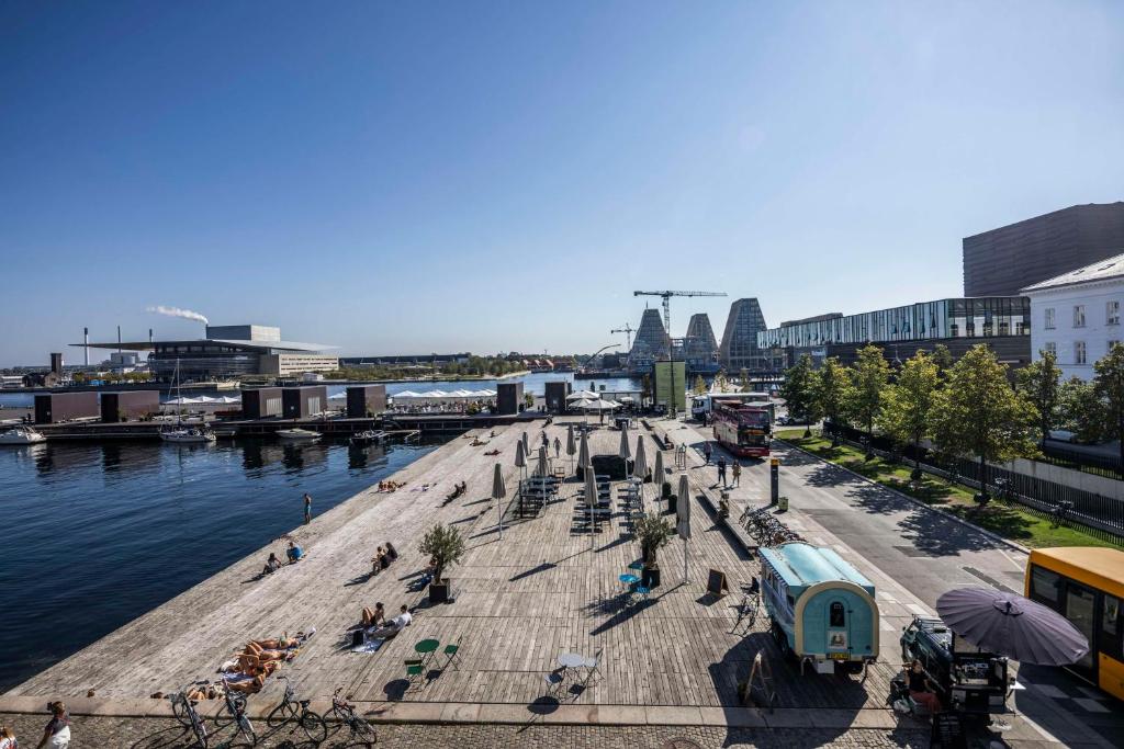 a pier with people sitting on the beach next to the water at Scandic Front in Copenhagen