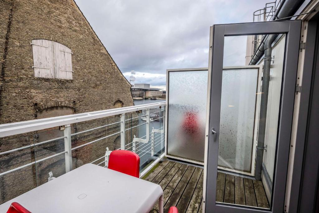 a balcony with a table and a red chair at Scandic Front in Copenhagen