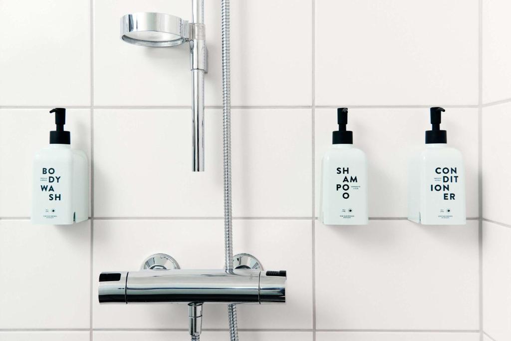 a bathroom with a sink and soap bottles on the wall at Scandic Tampere Station in Tampere