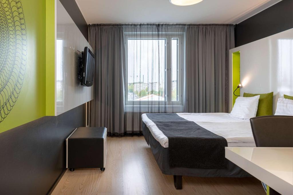 a hotel room with a bed and a window at Scandic Tampere Station in Tampere