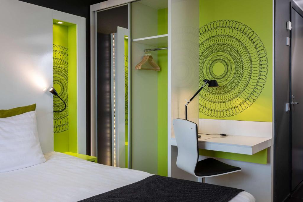 a bedroom with a bed and a desk and a chair at Scandic Tampere Station in Tampere