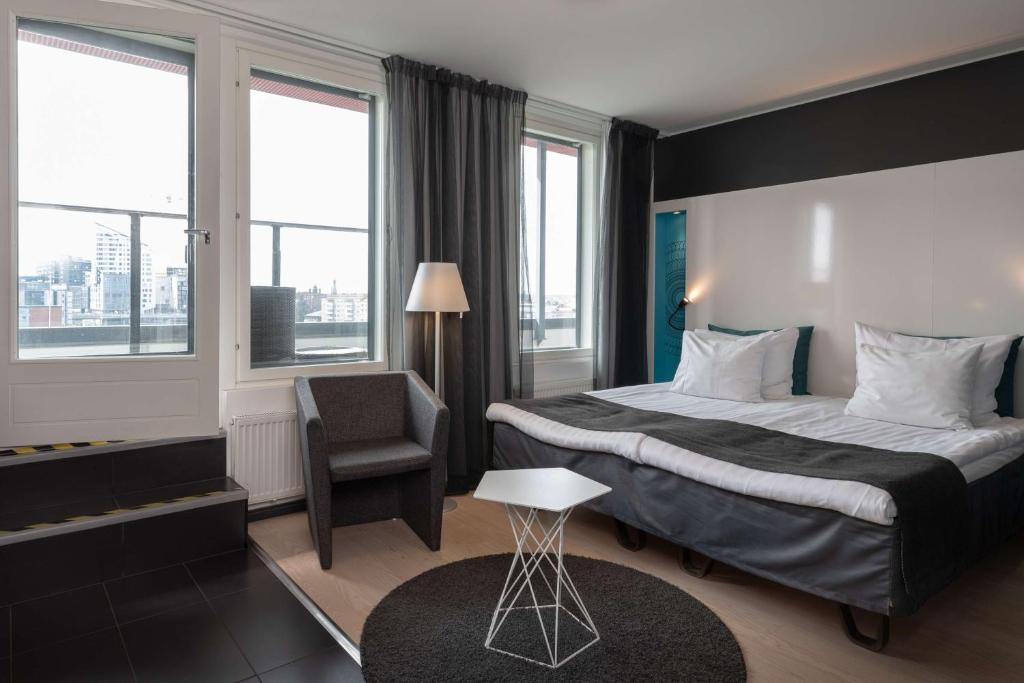 a hotel room with a bed and a chair at Scandic Tampere Station in Tampere