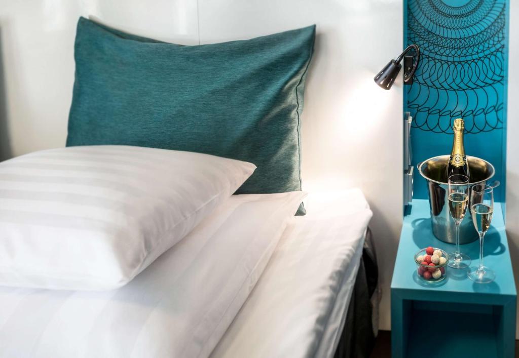 a bed with a green headboard and a table with a night stand at Scandic Tampere Station in Tampere