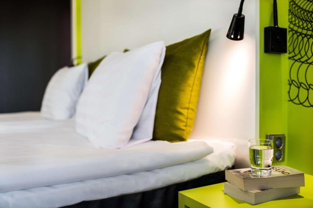 a bedroom with a bed with yellow and white pillows at Scandic Tampere Station in Tampere