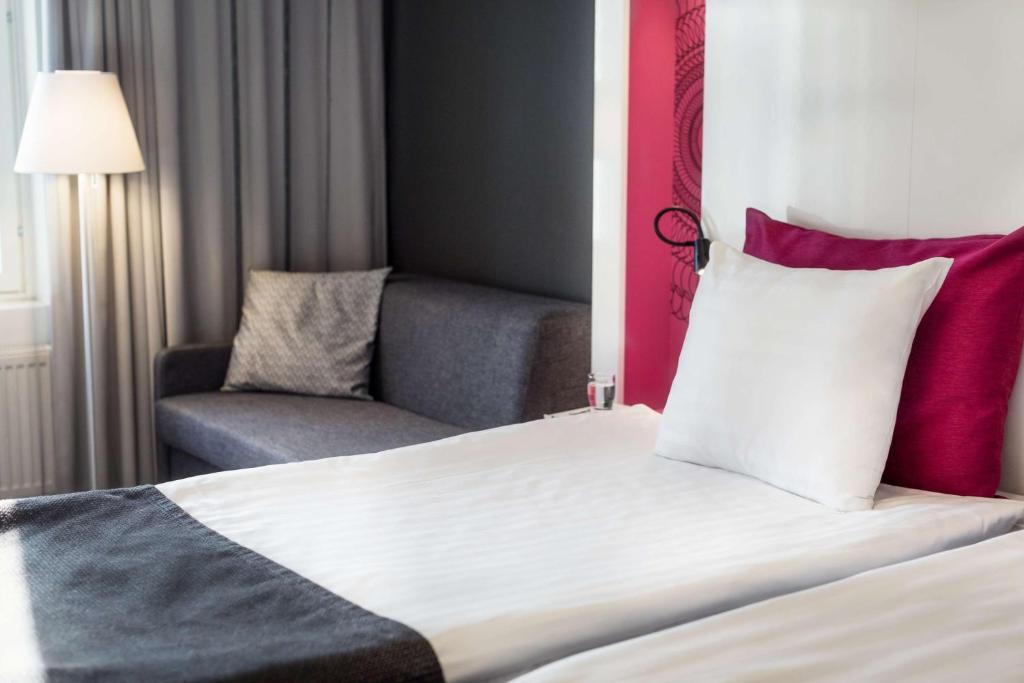 a hotel room with a bed and a chair at Scandic Tampere Station in Tampere