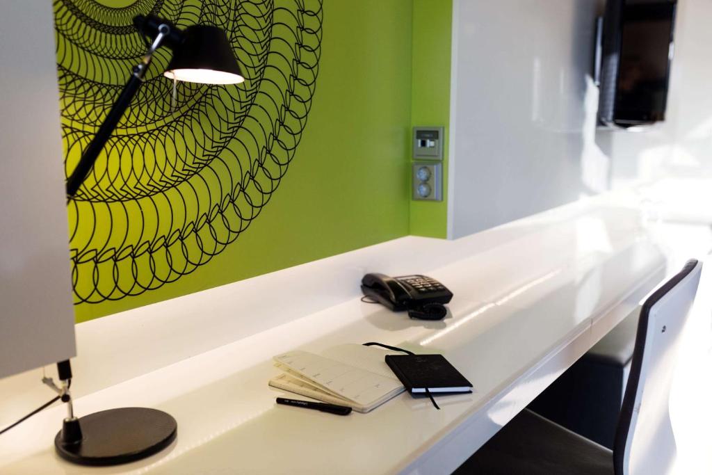 a desk with a lamp and a book and a phone at Scandic Tampere Station in Tampere