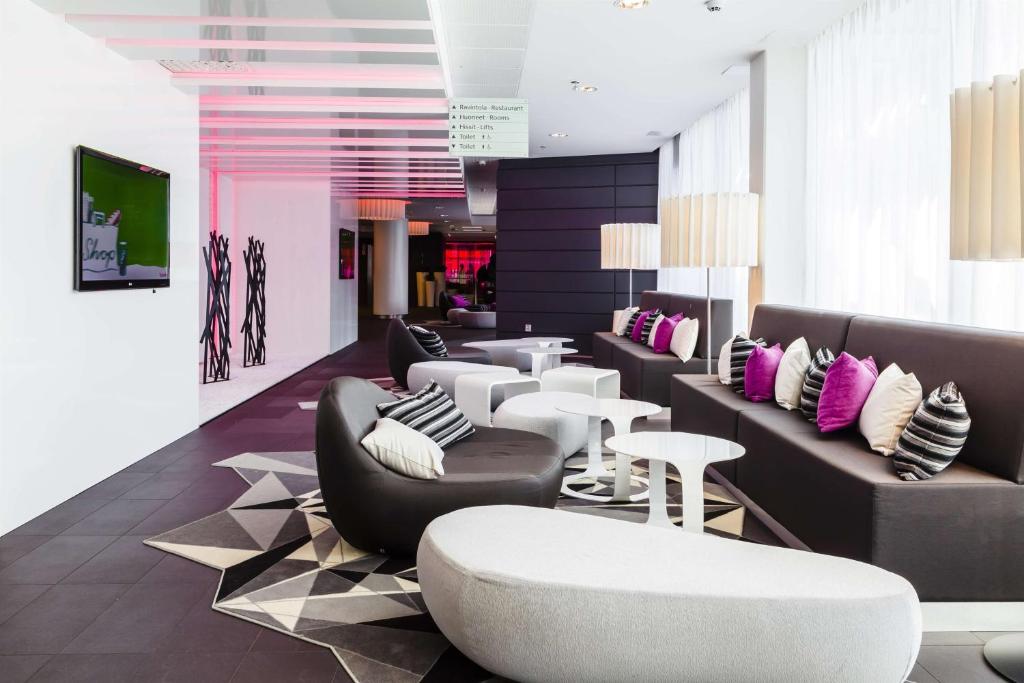 a lobby with couches and chairs and tables at Scandic Tampere Station in Tampere