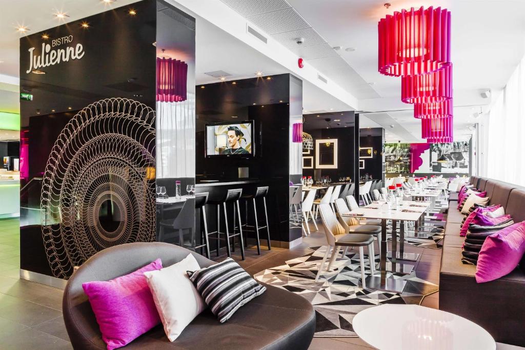 a restaurant with chairs and tables and pink chandeliers at Scandic Tampere Station in Tampere
