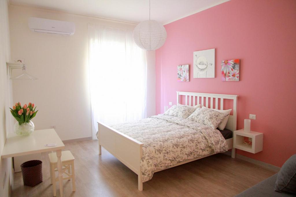 サレルノにあるB&B BuonaLunaのピンクの壁と白いベッドが備わるベッドルーム1室