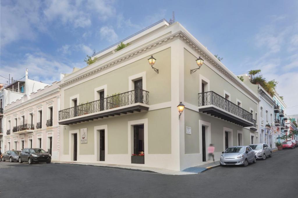 Biały budynek z samochodami zaparkowanymi przed nim w obiekcie Decanter Hotel w mieście San Juan