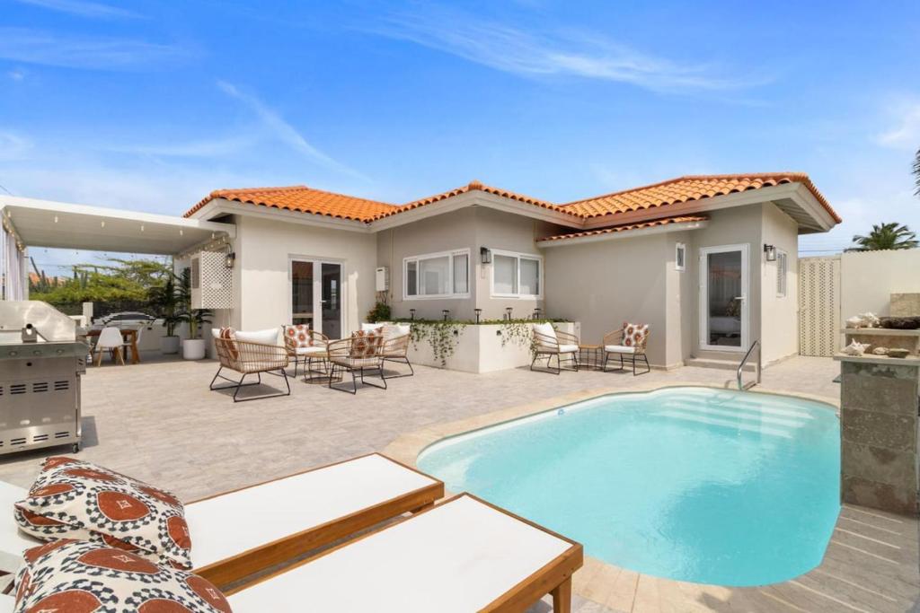 a house with a swimming pool and a patio at 3BR Private Pool Retreat 4 Mins Drive by Bocobay in Palm-Eagle Beach