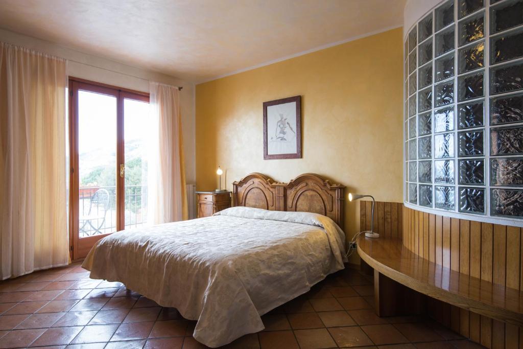a bedroom with a large bed and a large window at B&B La Mimosa del Golfo in Ospedaletti