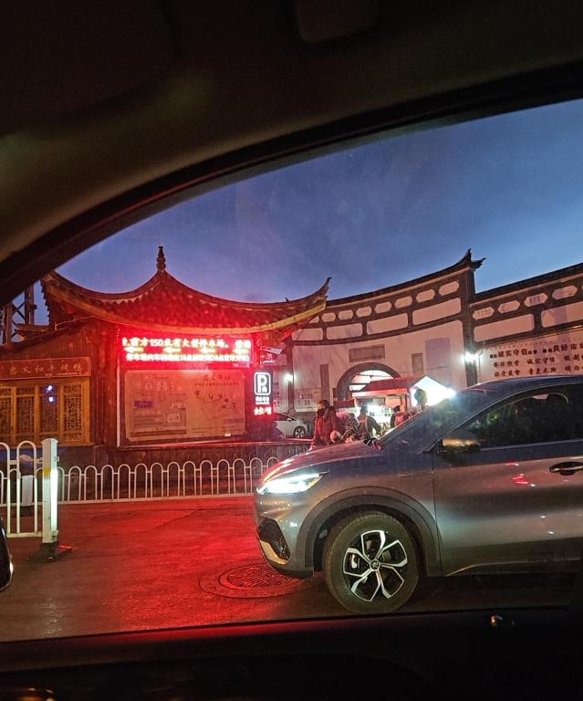 a car parked in front of a building at night at 国泰府Cathay old town palace古城观景客栈 丽江古城大水车店 in Lijiang