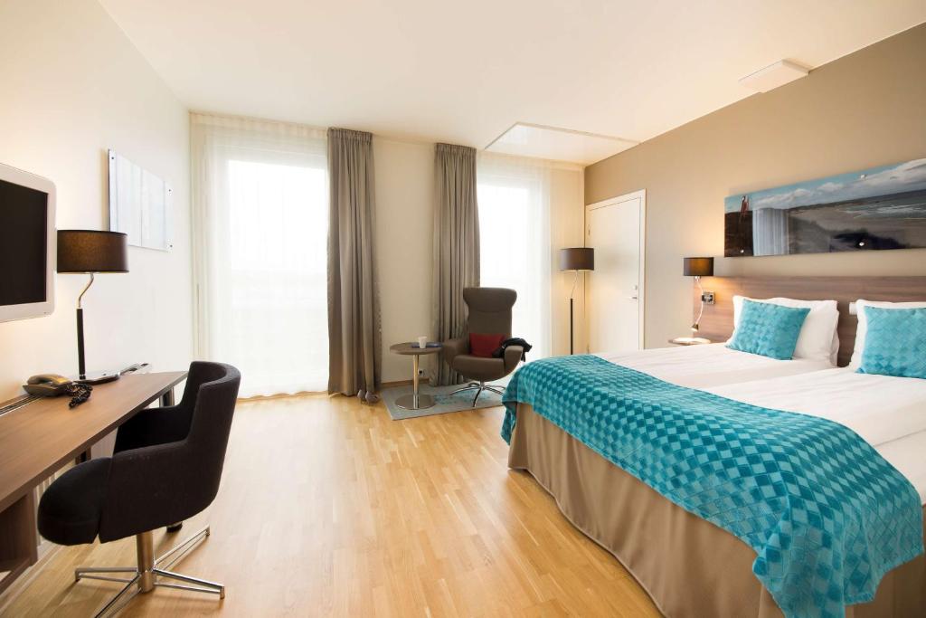 a hotel room with a bed and a desk at Scandic Stavanger Airport in Sola