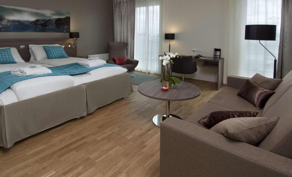 a bedroom with a bed and a living room at Scandic Stavanger Airport in Sola