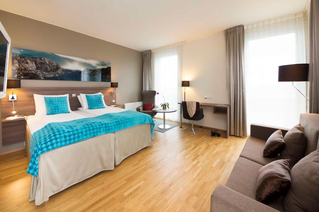 a bedroom with a large bed and a couch at Scandic Stavanger Airport in Sola
