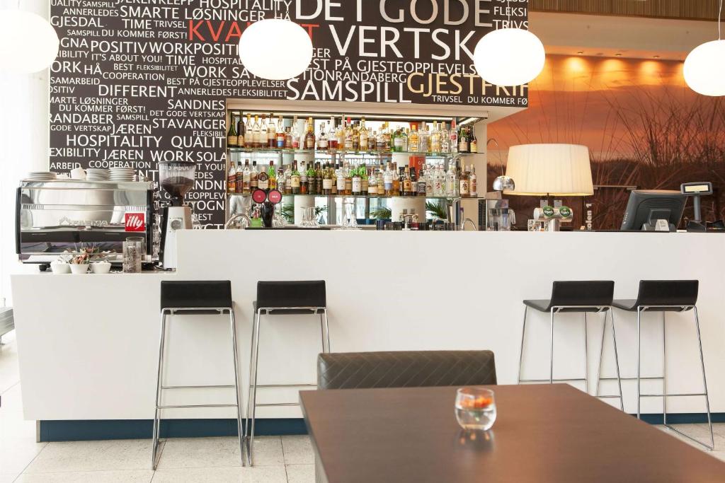 a bar with stools in a restaurant with a counter at Scandic Stavanger Airport in Sola
