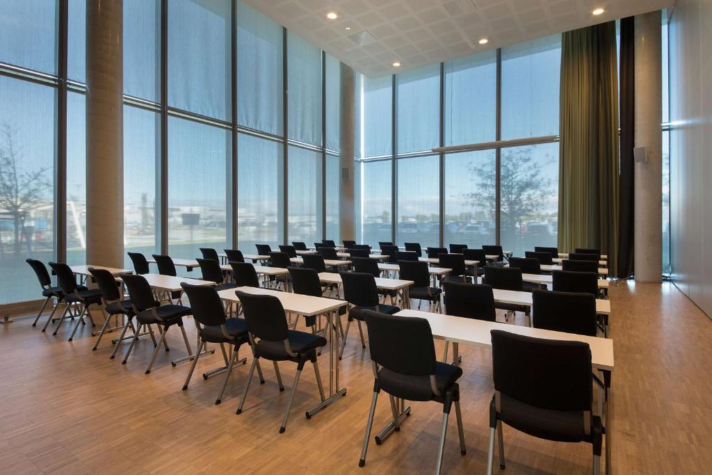 a conference room with tables and chairs and large windows at Scandic Stavanger Airport in Sola
