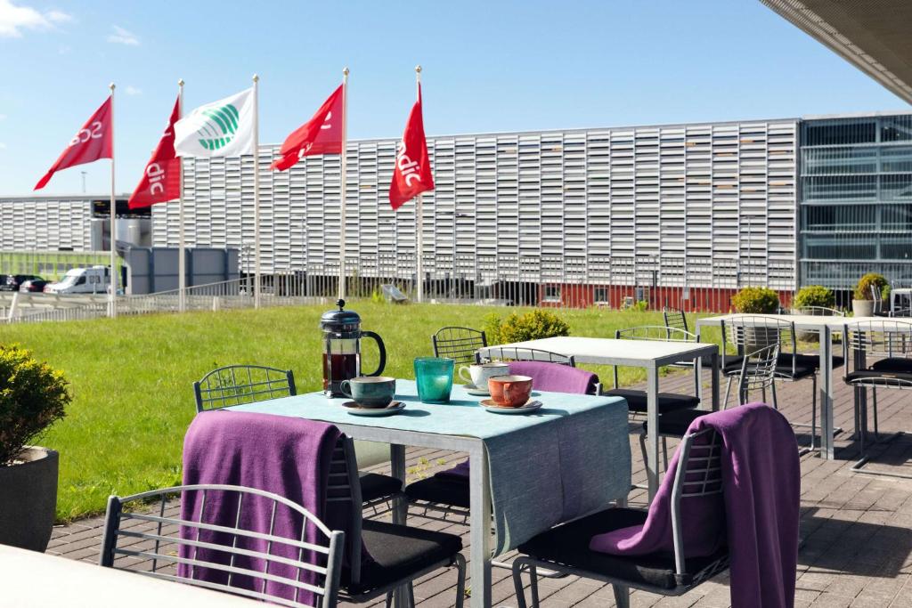 a group of tables with purple chairs and flags at Scandic Stavanger Airport in Sola