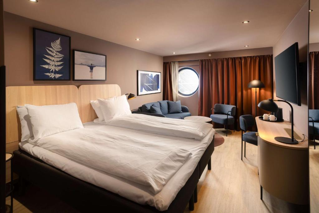 a hotel room with a large bed and a desk at Scandic Victoria in Oslo