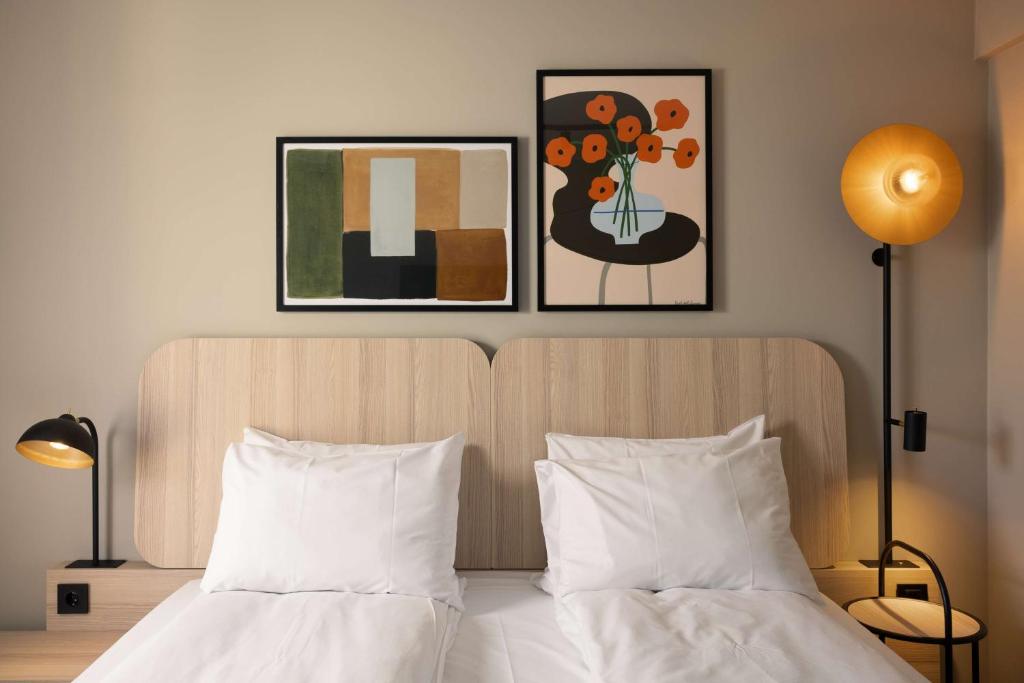 a bedroom with a bed with two pictures on the wall at Scandic Victoria in Oslo