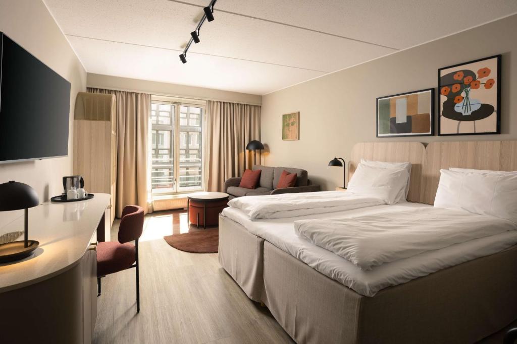 a hotel room with a bed and a couch at Scandic Victoria in Oslo