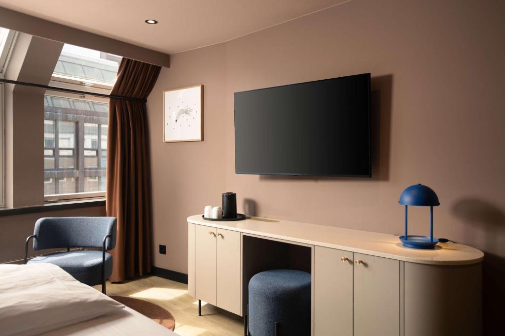 a hotel room with a bed and a tv on the wall at Scandic Victoria in Oslo