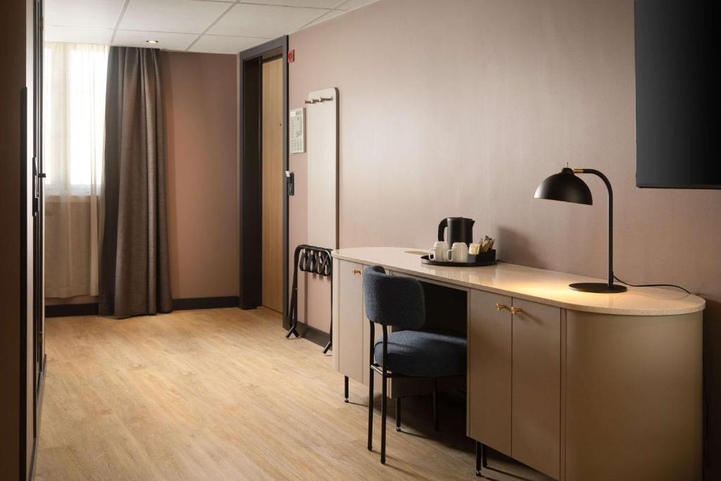 a room with a desk with chairs and a lamp at Scandic Victoria in Oslo