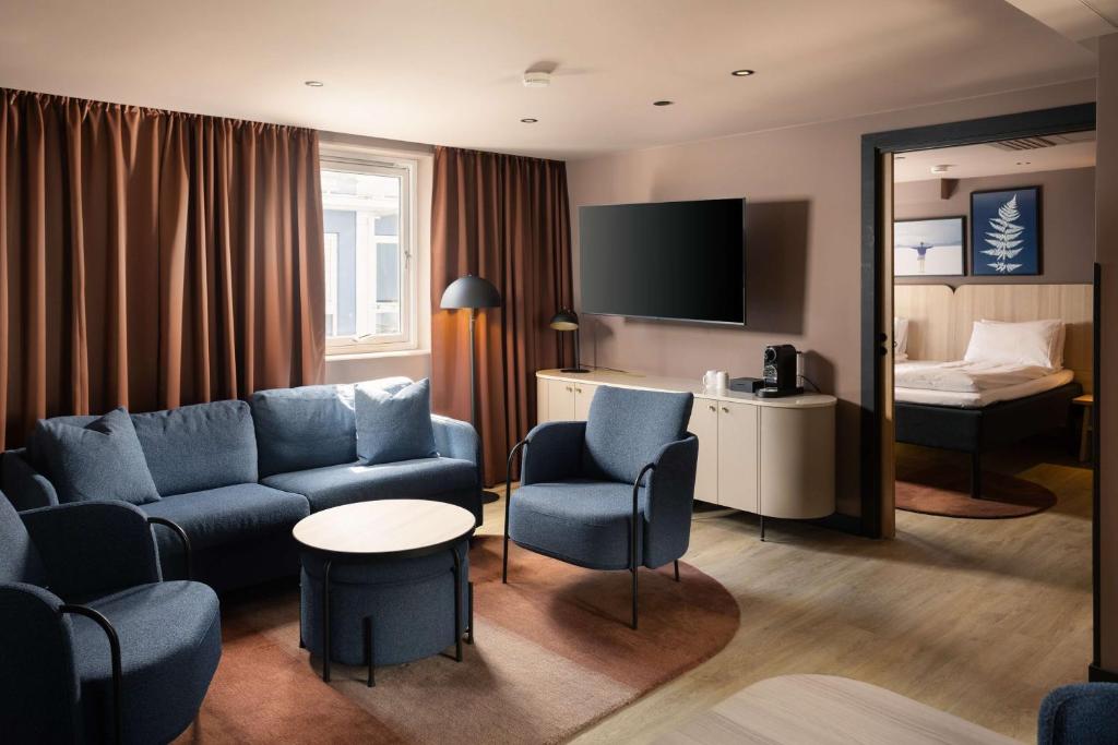 a hotel room with a couch and a bed at Scandic Victoria in Oslo